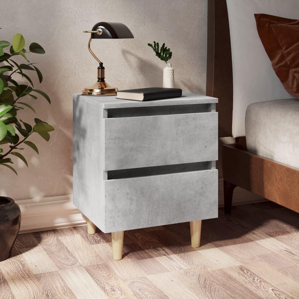 A bedside table with a lamp and a book next to a bed.