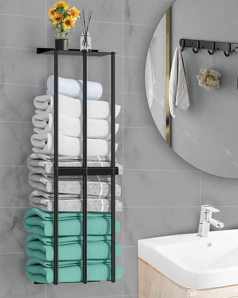 A bathroom shelf with folded towels and a sink.