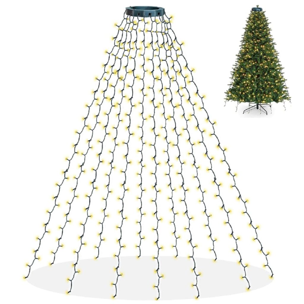 A Christmas tree light string draped over a white background, with a decorated Christmas tree in the background.