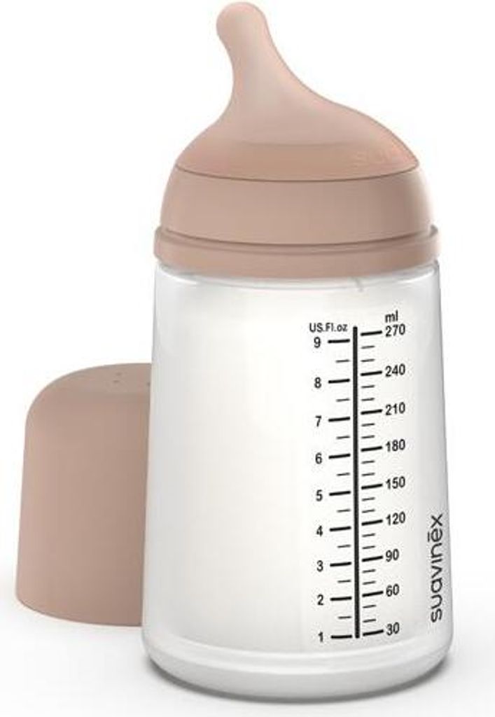 A baby bottle with a beige cap and a beige nipple, filled with a white liquid. The bottle has measurement markings on the side.