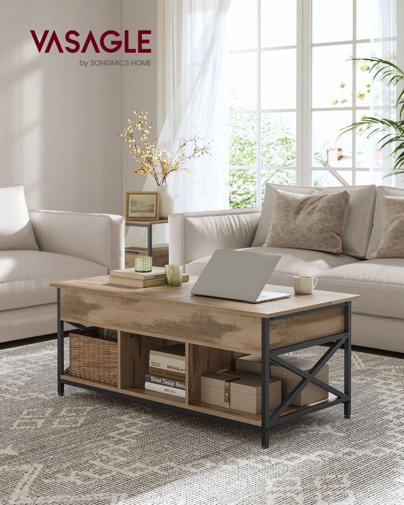 A living room scene featuring a coffee table with a laptop and decor, in front of a sofa and window.