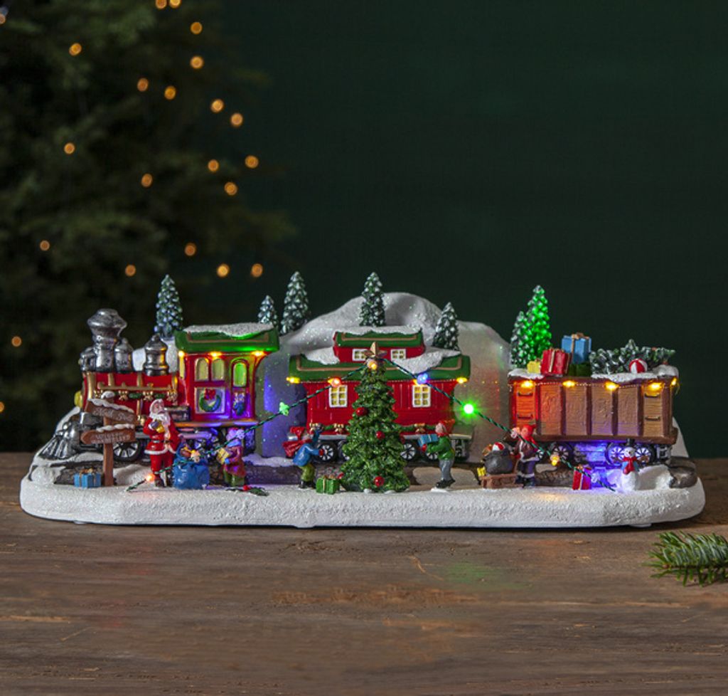 A festive Christmas train scene with Santa and elves.