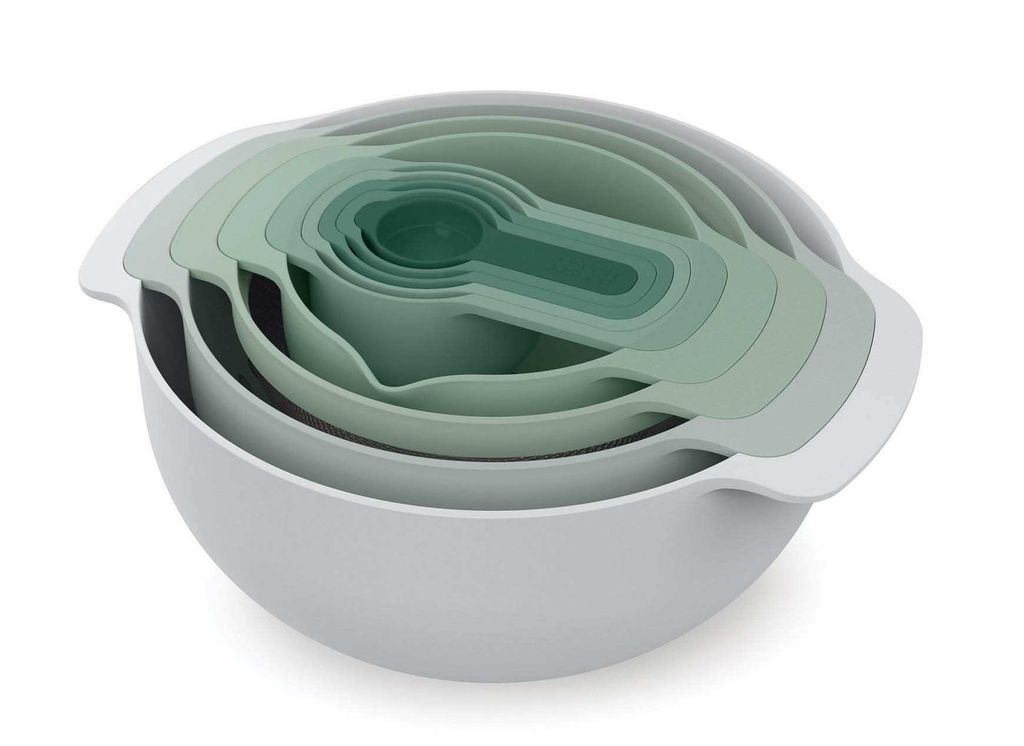 A set of nesting mixing bowls and measuring cups in various shades of green and gray, stacked together.
