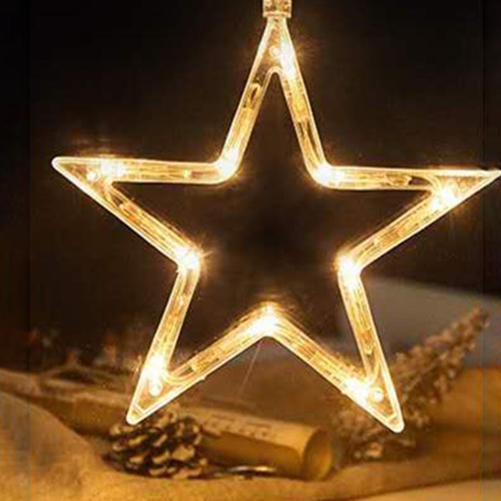 A star-shaped LED light decoration hangs in front of a dark background, with some decorative elements like pinecones and a rolled-up scroll visible in the foreground.