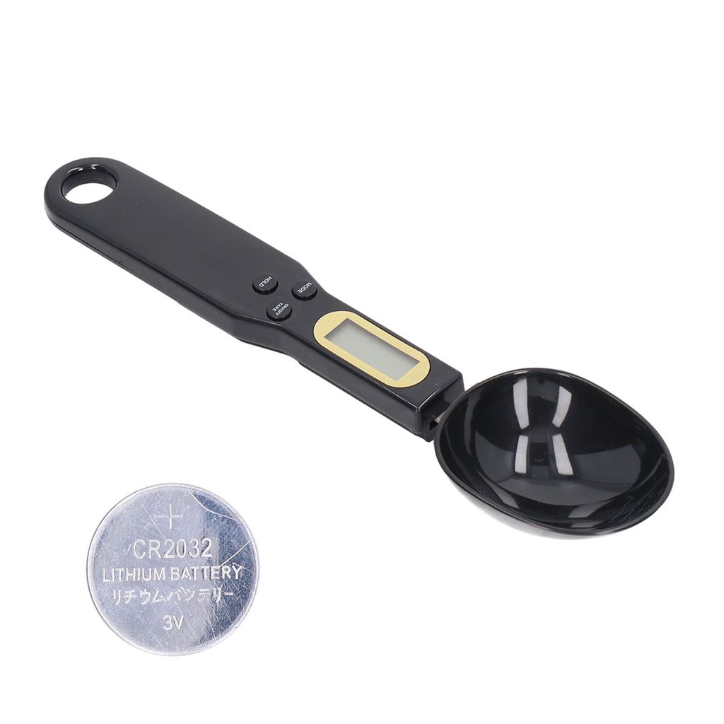 A black digital measuring spoon and a coin battery on a white background.