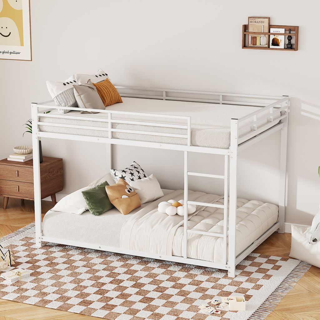 A white metal bunk bed with bedding and pillows in a bedroom setting.