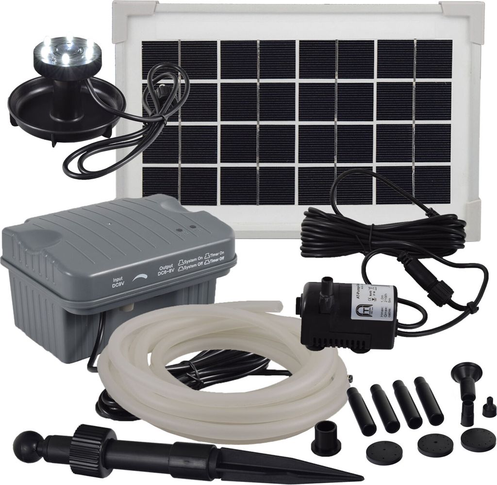 A collection of solar-powered water pump components, including a solar panel, pump, tubing, and LED light, laid out on a white background.