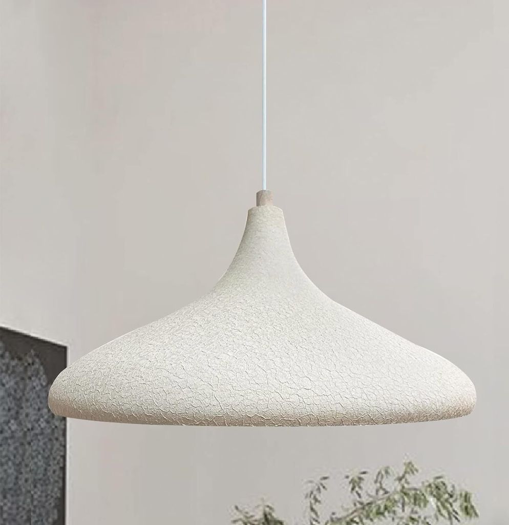 A pendant lamp hangs from a white cord against a light gray and white background.