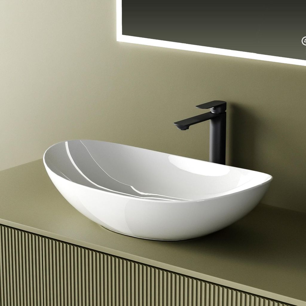 A white oval vessel sink with a black faucet is shown on a green vanity with a ribbed texture. A lit mirror is visible in the background.