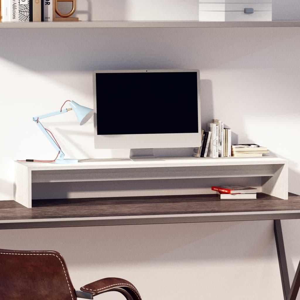 A monitor stand on a desk with a monitor, lamp, and books.