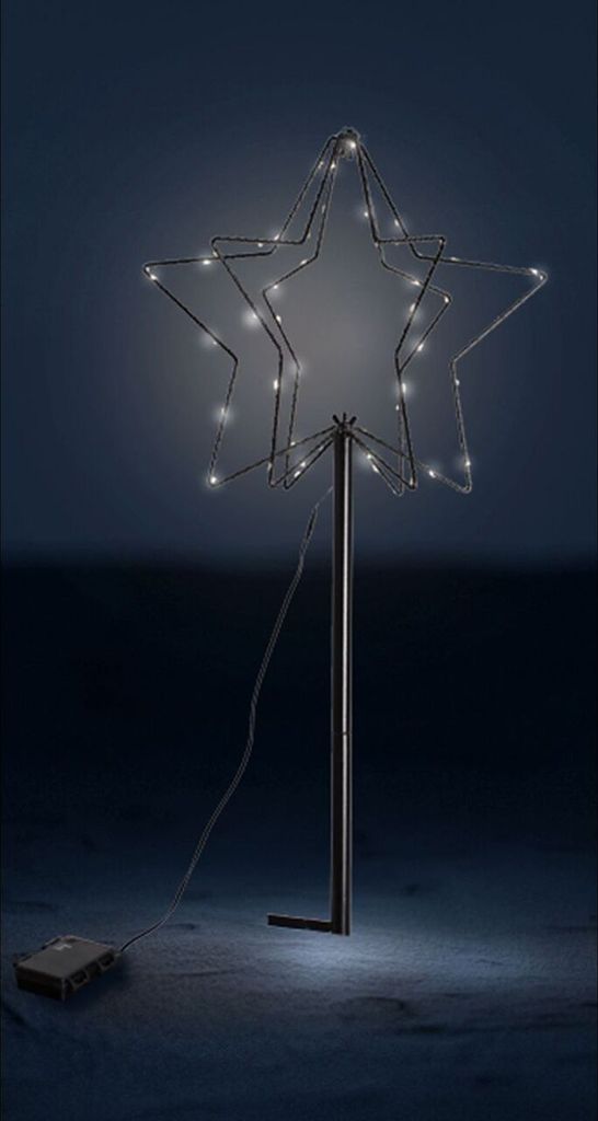 A lit-up star decoration on a dark background.