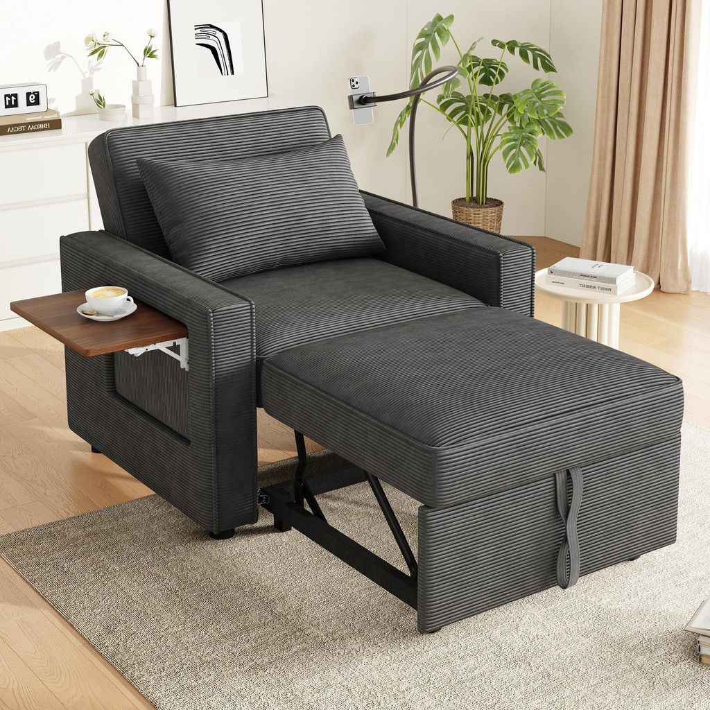 A dark gray convertible sofa bed with an ottoman and a small side table with a cup of coffee on it, set in a living room environment.