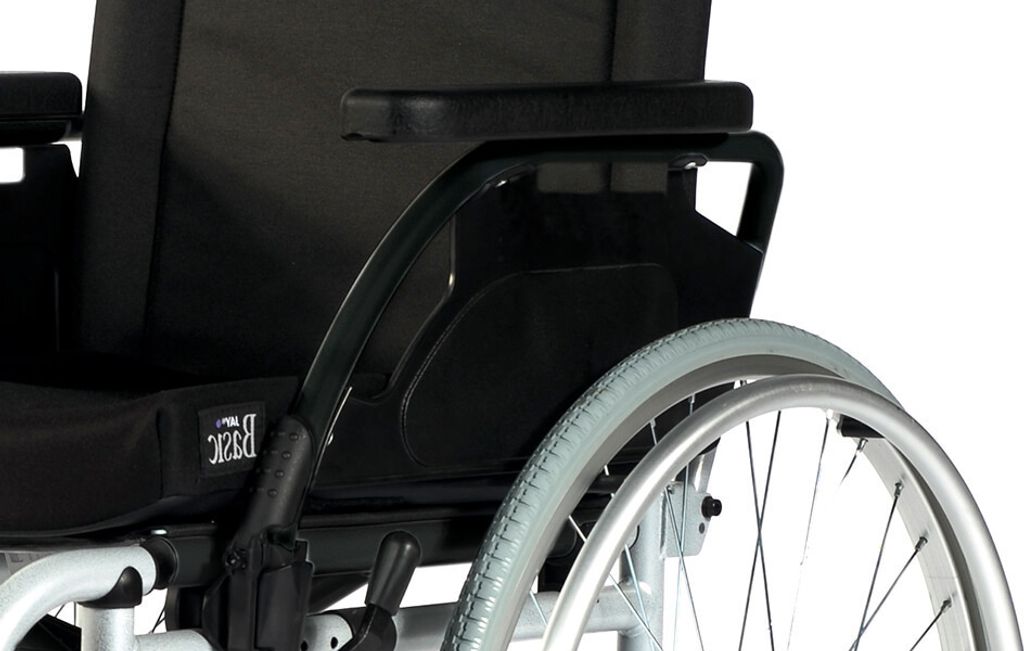 A close-up view of the rear section of a wheelchair, focusing on the wheel and armrest.