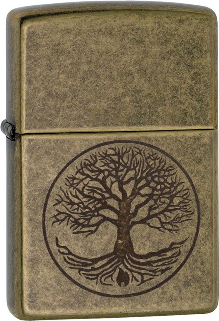 A close-up, front-facing view of a Zippo lighter with an antique brass finish, featuring an engraved 'Tree of Life' design.
