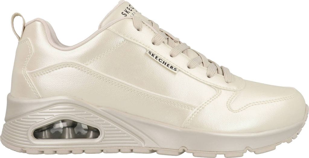 A side view of a beige Skechers sneaker.