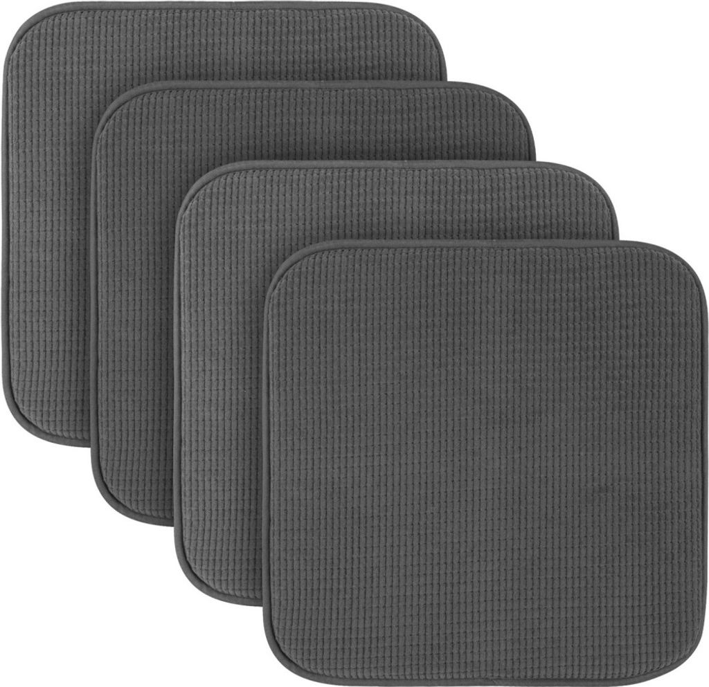 A stack of four dark gray seat cushions.