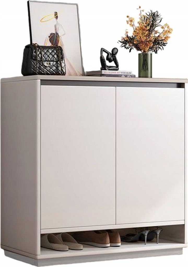 A white shoe cabinet with various decorative items on top and shoes on the bottom shelf.
