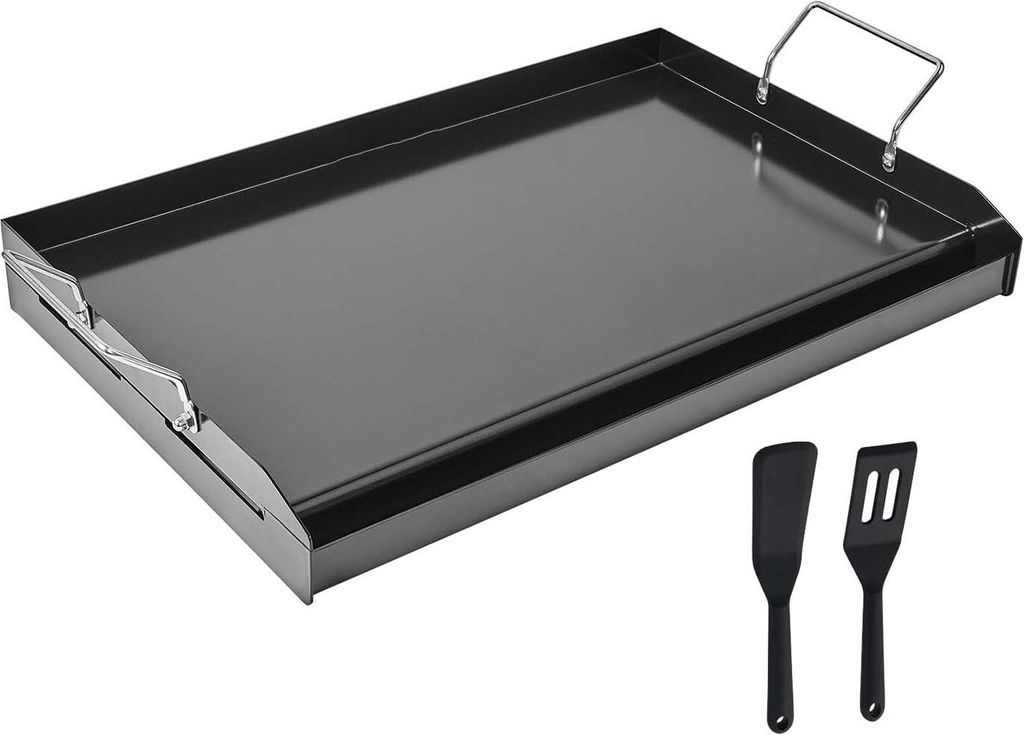 A black steel griddle plate with two black spatulas on a white background.