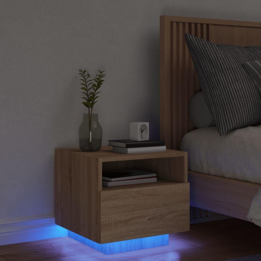 A bedside table with LED lighting next to a bed.