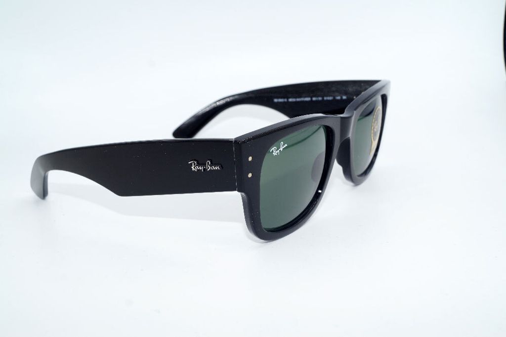 A pair of black sunglasses with green lenses is displayed against a white background.