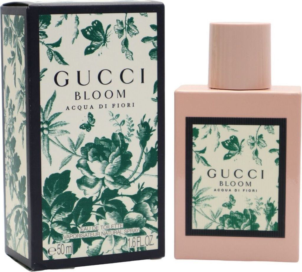 Gucci Bloom Acqua di Fiori Eau de Toilette in rosa Flakon mit floralem Etikett, daneben passende grün-beige Box mit Blumen- und Schmetterlingsmuster.
