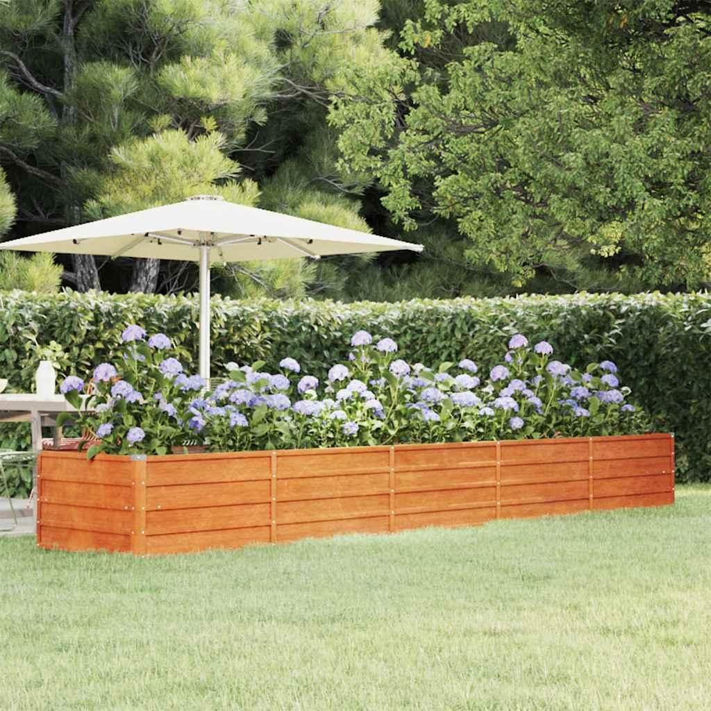 A raised garden bed filled with hydrangeas in a backyard setting with a patio umbrella.