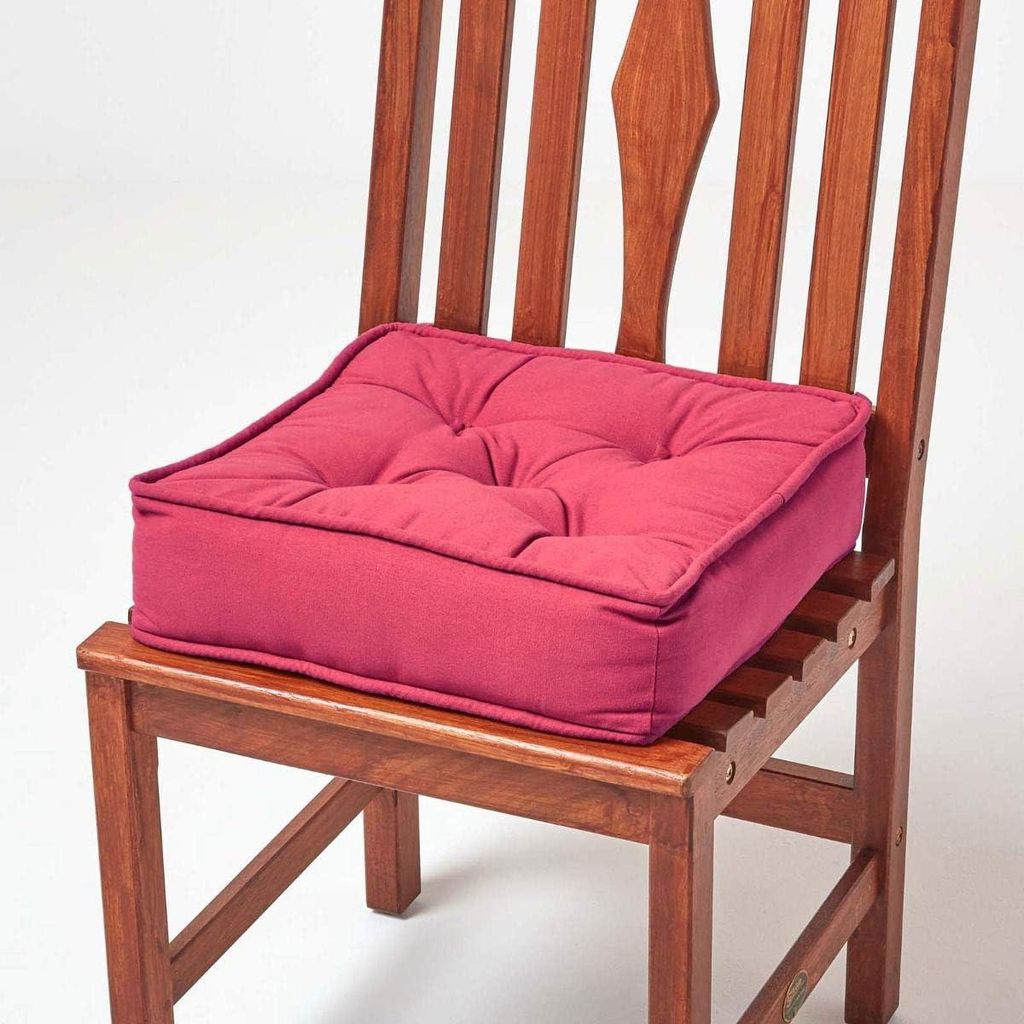 A red seat cushion on a wooden chair.