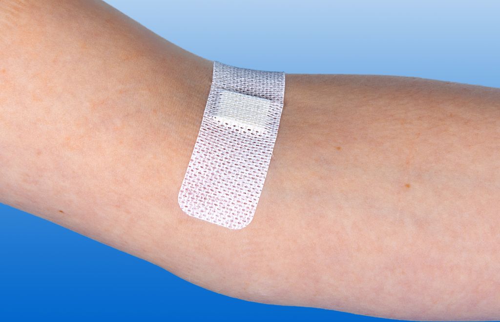 A close-up shot of a medical bandage on a person's arm.