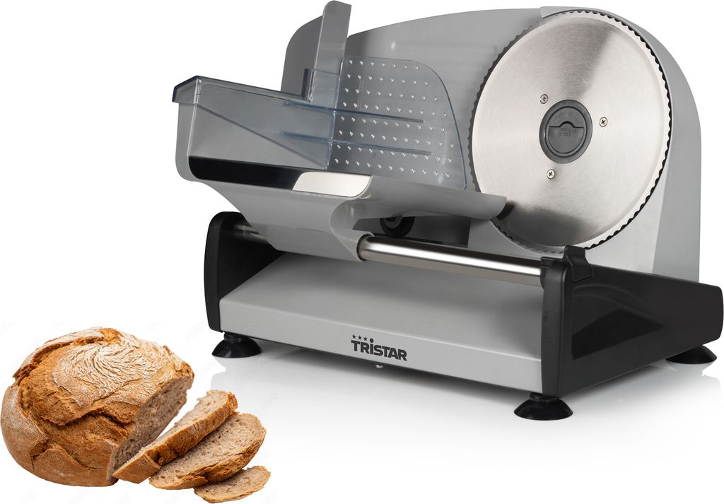 A food slicer machine with a loaf of bread and slices next to it.