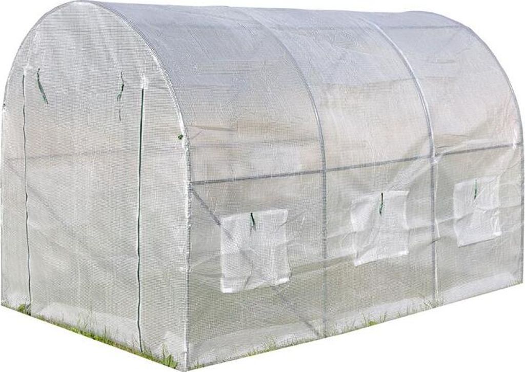 A white greenhouse with a curved roof and windows on the side, set on grass.