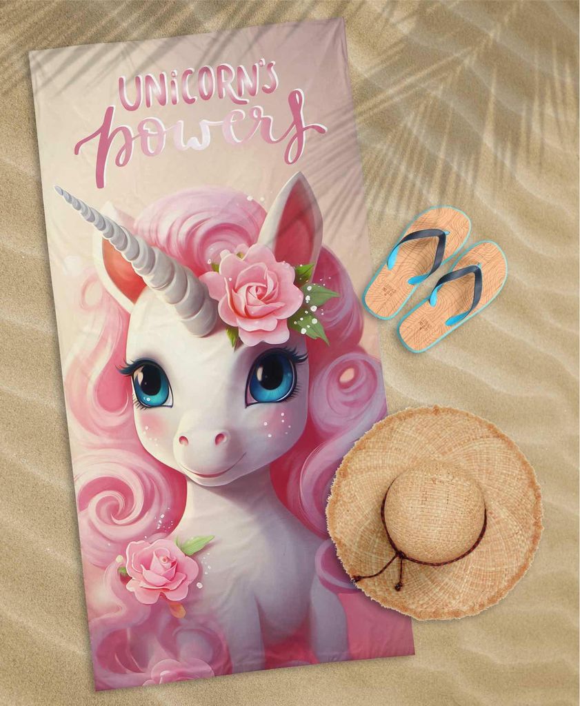 A beach scene with a unicorn towel, flip-flops, and a straw hat.