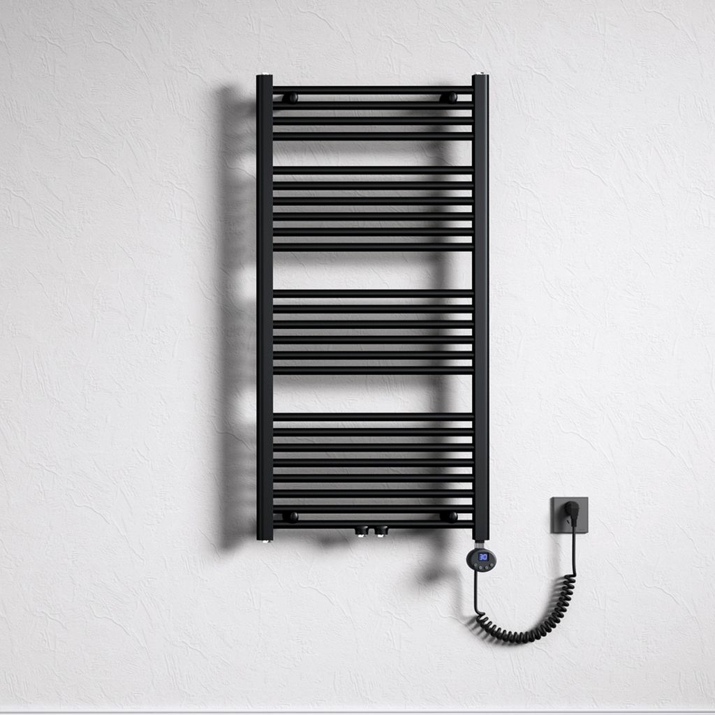 A black electric towel radiator mounted on a textured white wall, with its power cord plugged into a wall socket.