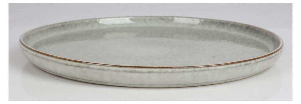 A single ceramic plate shown from a side-diagonal angle on a white and light gray background.