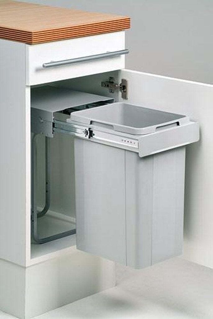 A pull-out trash can system installed in a kitchen cabinet.