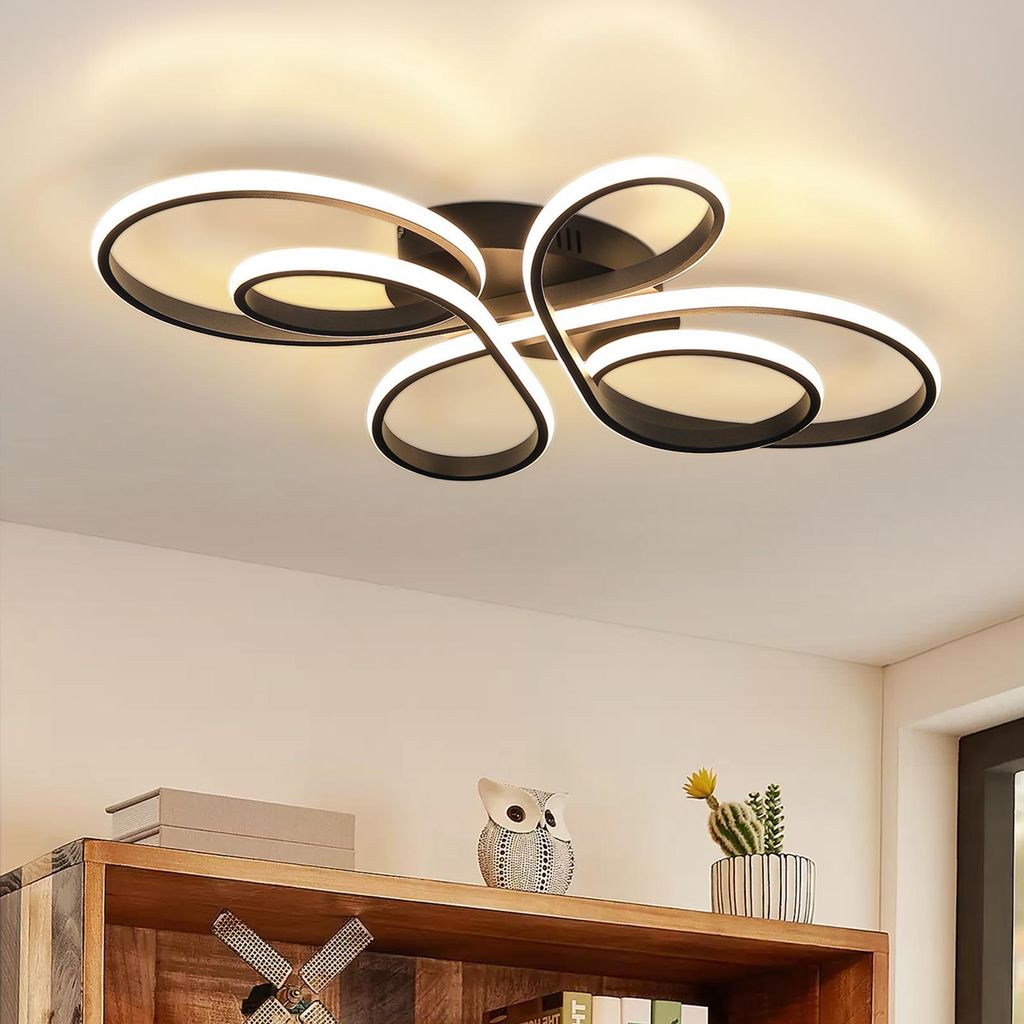 A modern ceiling light fixture with a swirling design, mounted on a white ceiling.