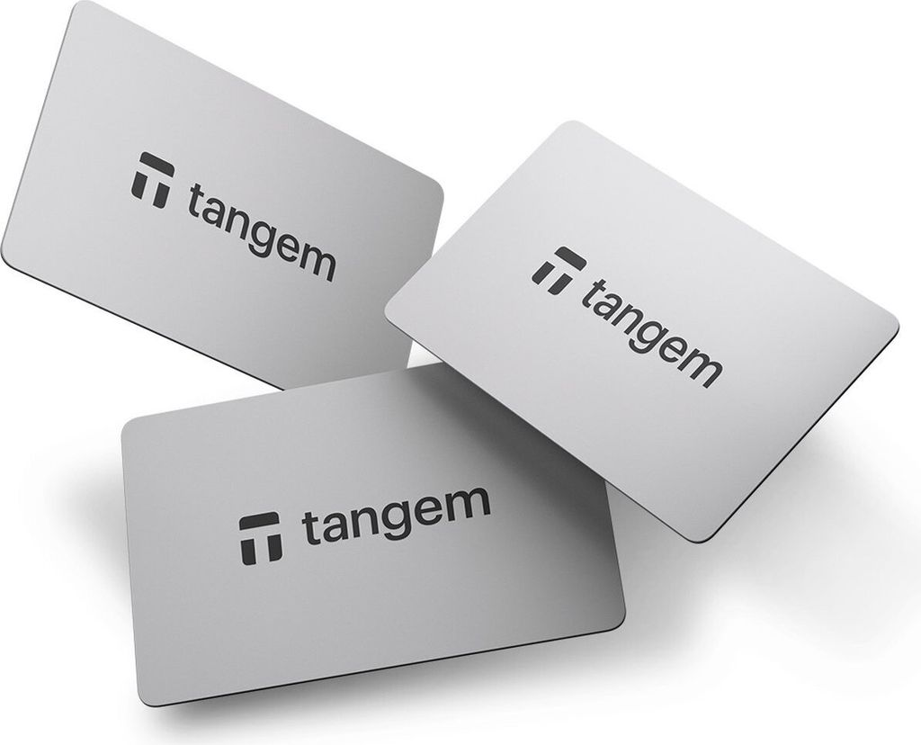 Three silver-colored cards with the Tangem logo and text are arranged in a scattered formation on a white background.