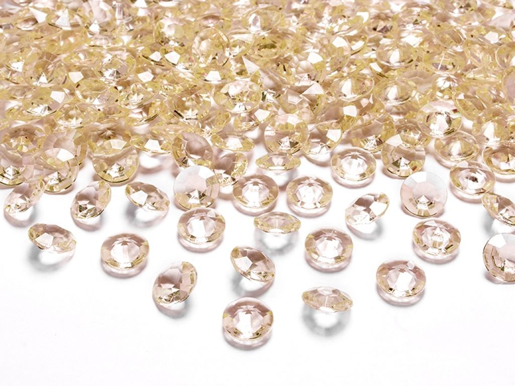 A pile of small, faceted, gold-colored confetti pieces, resembling diamonds, scattered on a white surface.