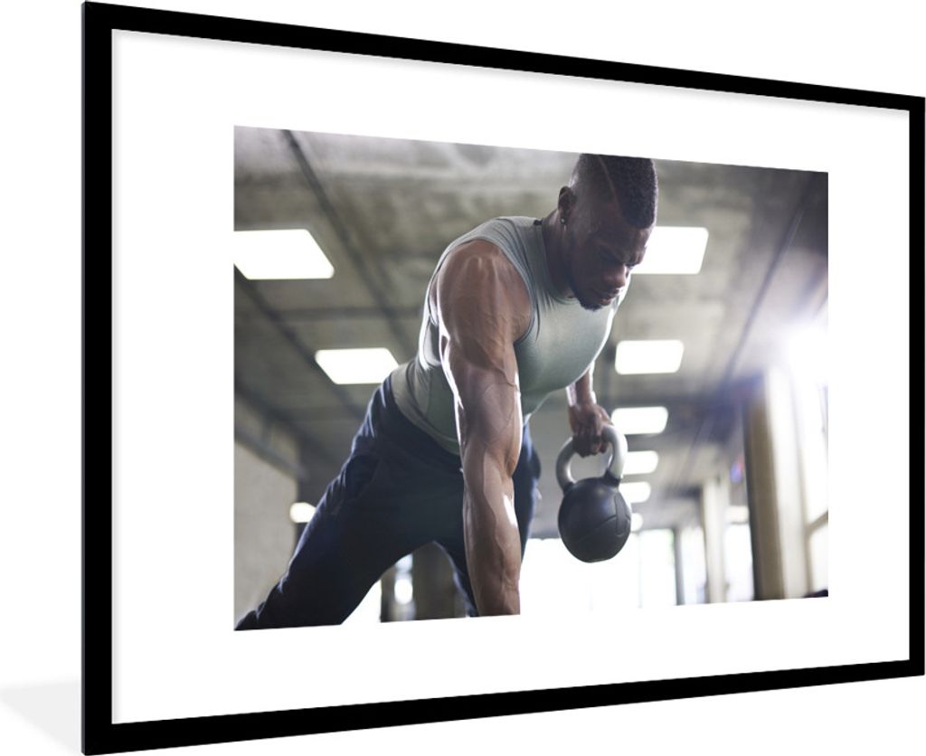 MuchoWow Gerahmtes Poster Ein starker Mann hebt Kettlebells beim Fitness 90x60 cm - Poster mit Schwarzem Bilderrahmen Wandposter Rahmen Foto Bild...