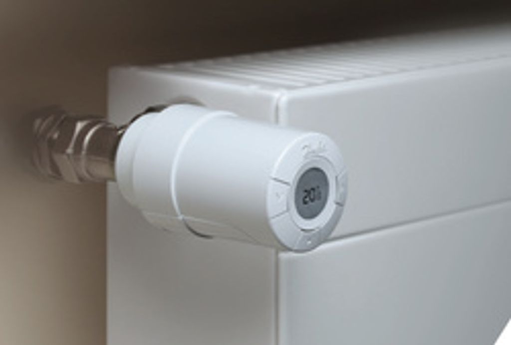 A close-up shot of a white radiator valve with a digital display showing '20°'.