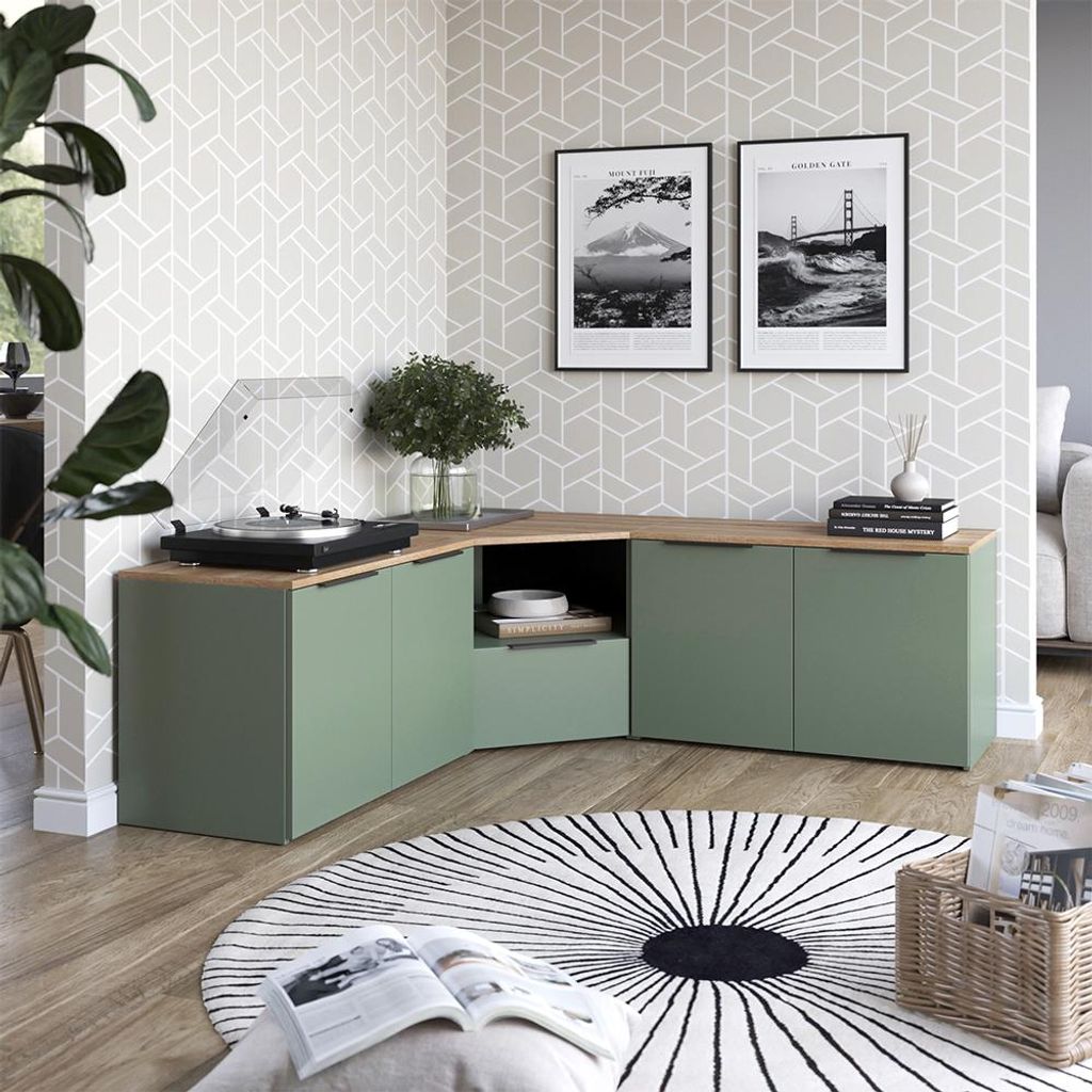 A modern living room corner with a green modular media console, turntable, artwork, and a round rug.