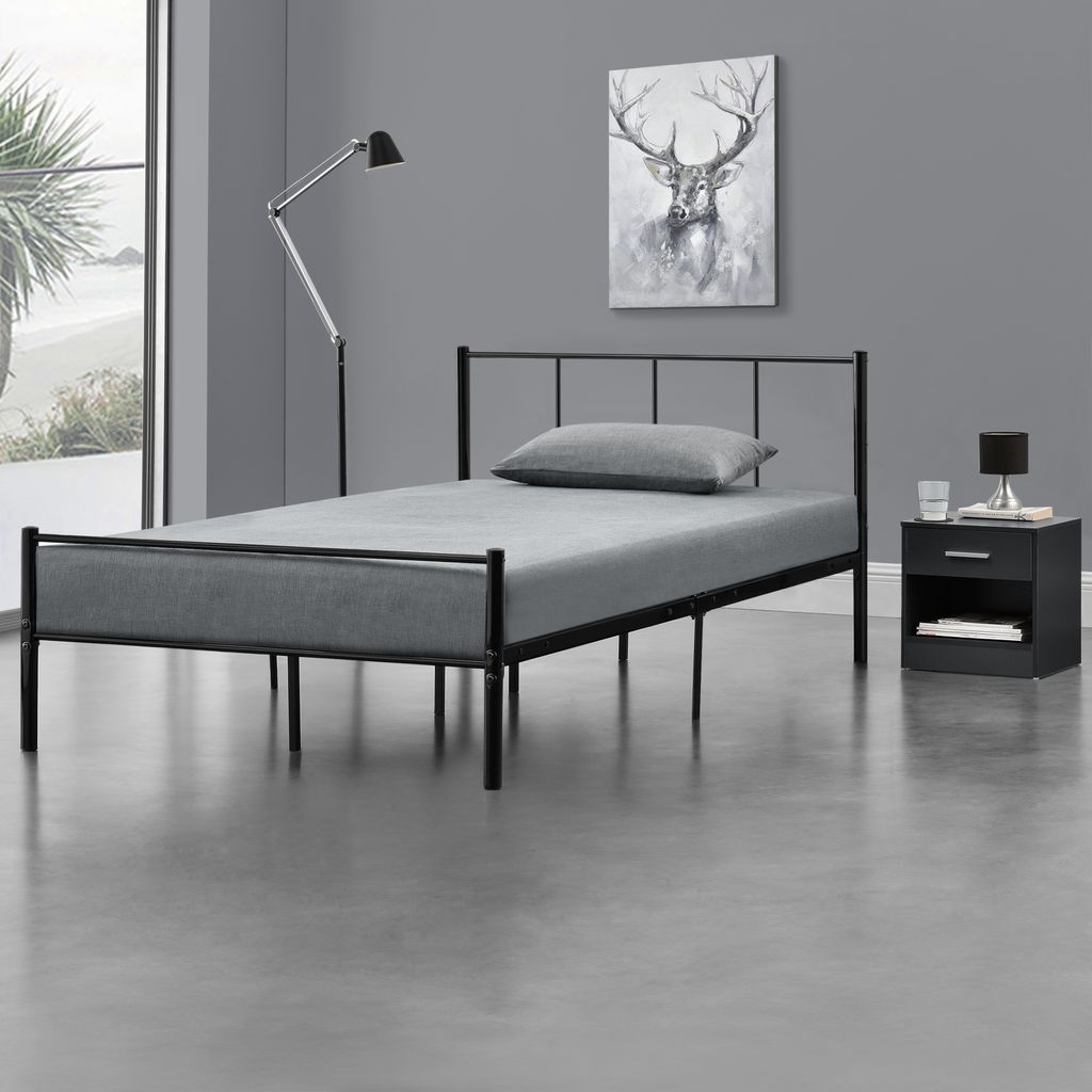 A bedroom scene with a bed, nightstand, and artwork.