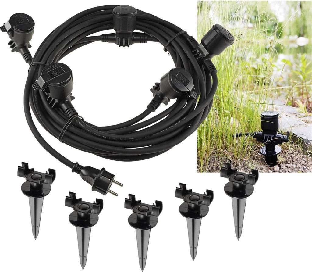 A black extension cord with multiple outlets and stakes for outdoor use, shown against a natural outdoor background.