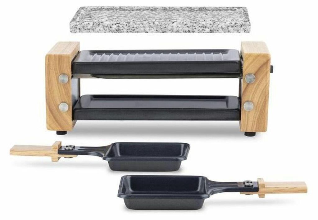 A raclette grill with a granite stone top and two small pans with wooden handles.
