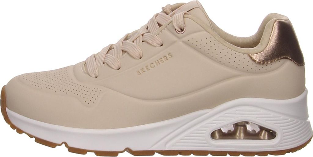 A side view of a single beige sneaker with a white sole and brown outsole.