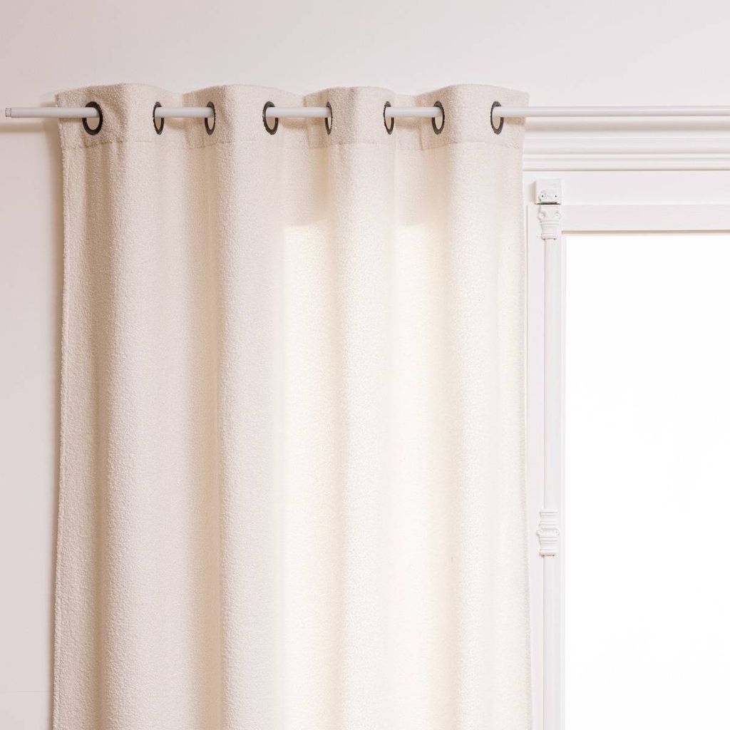 A close-up view of a white curtain hanging from a curtain rod.
