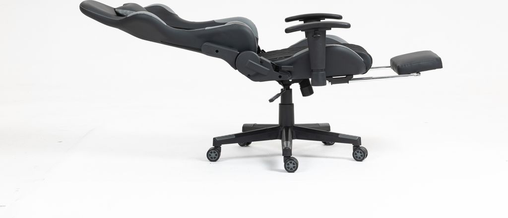 A black and gray gaming chair with a footrest extended, shown from the side against a white background.