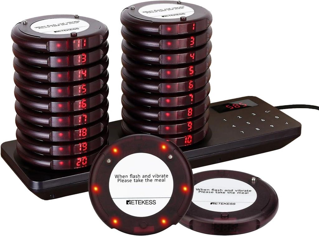 A set of restaurant pagers and their charging base.