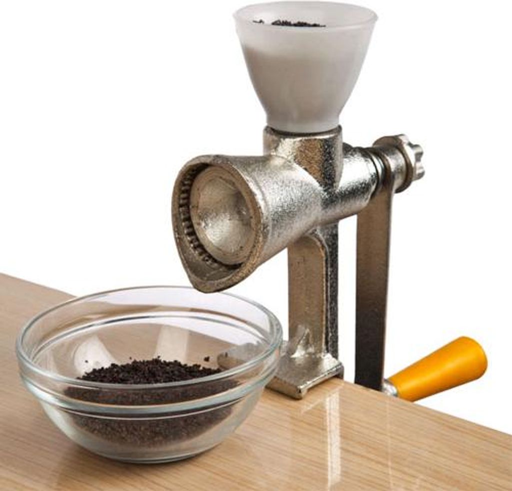 A manual grinder with a bowl of ground material on a wooden surface.