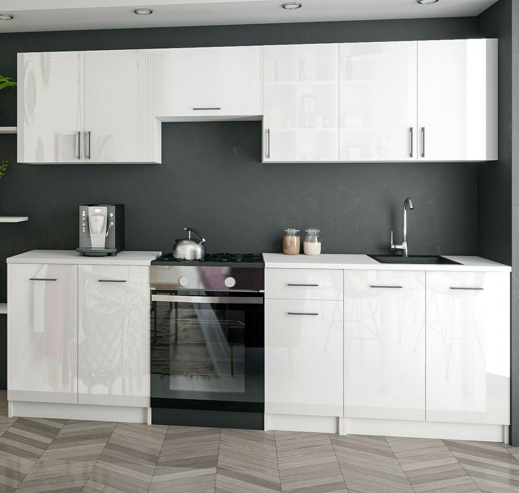 A modern white high-gloss kitchen unit with appliances.