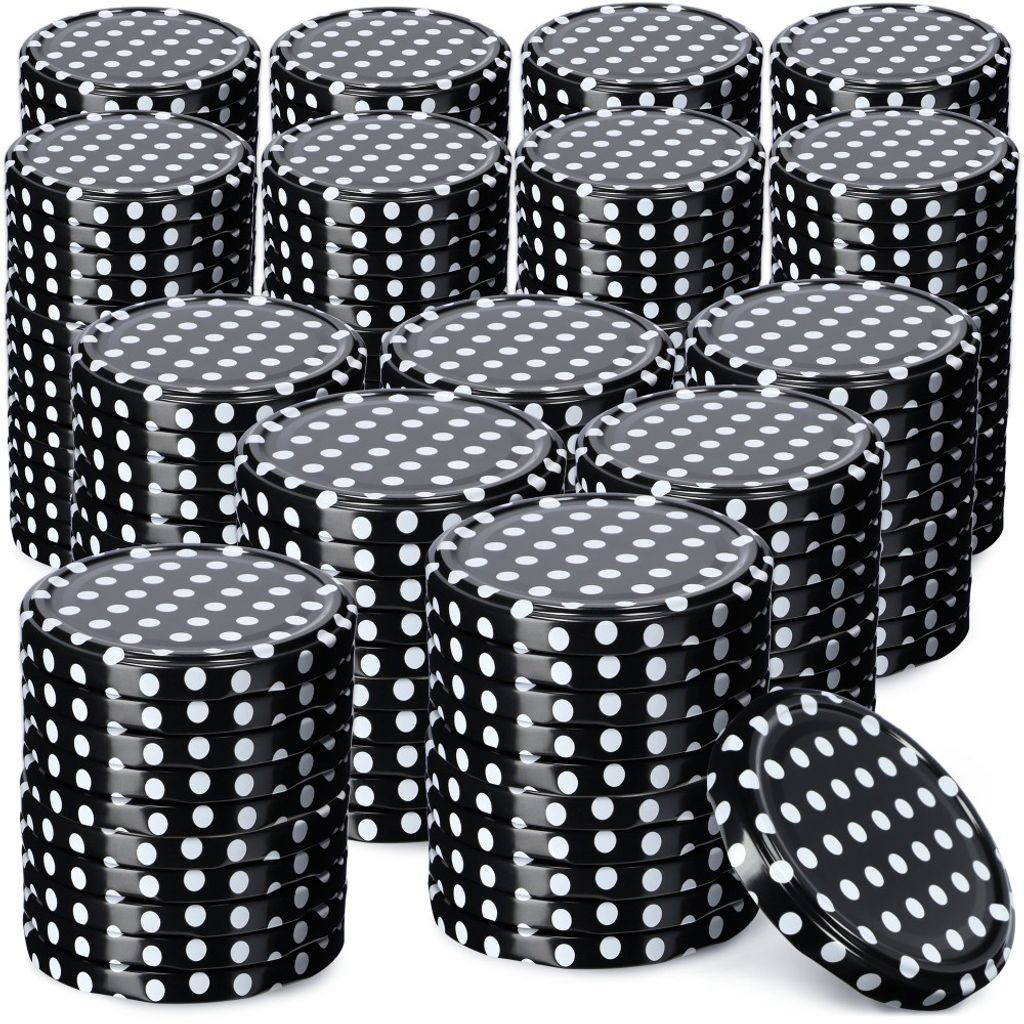 A collection of black metal lids with white polka dots, stacked in various arrangements.